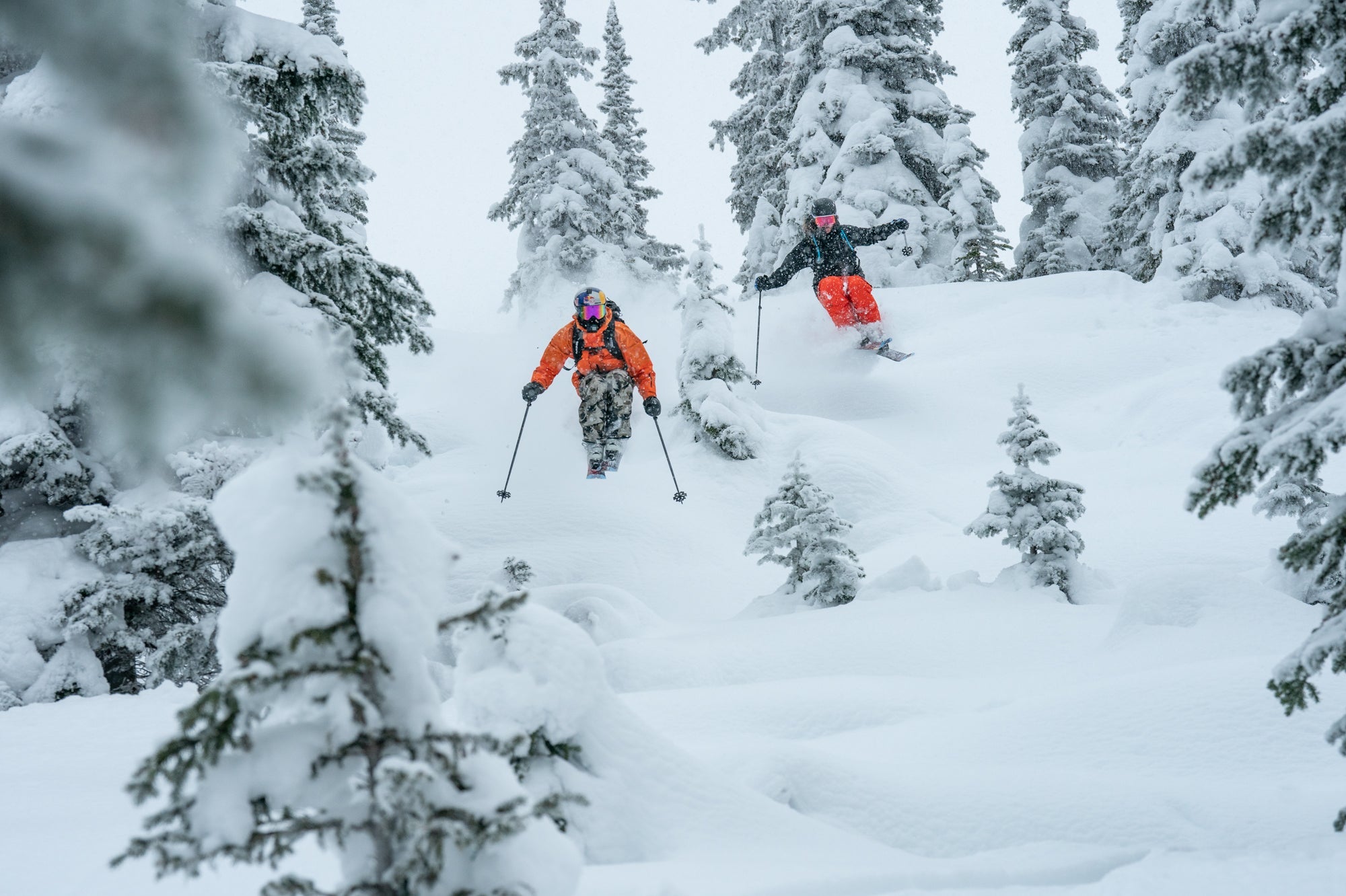 Two skiers powder skiing Atomic skis