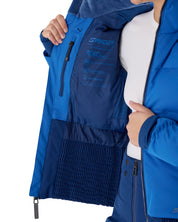 Close-up of a person wearing a blue Spyder ski jacket, opening the hood to reveal the interior lining with technical text and logos.