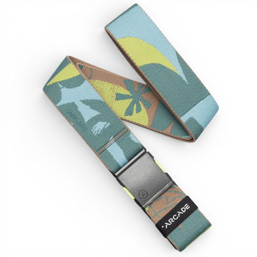 A canvas web belt by Arcade featuring a retro surfboard pattern in teal, yellow, brown, and light blue, with a matte black buckle and a black brand tag.